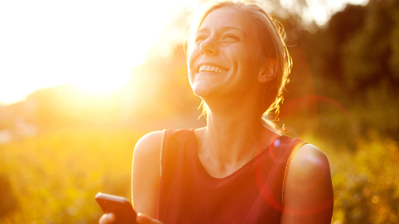 Young woman using smart phone at sunset