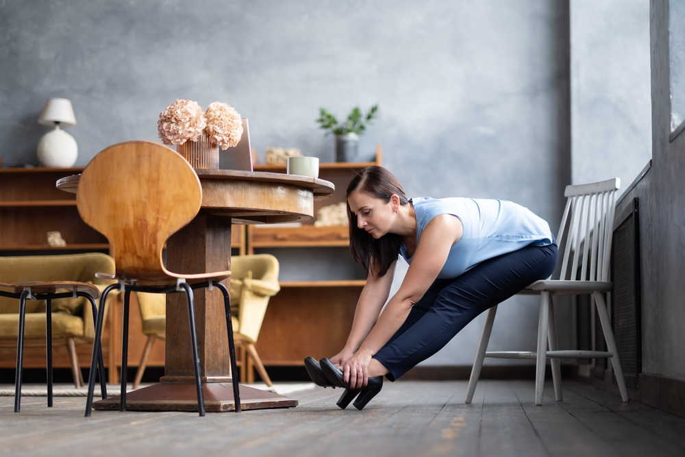 woman stretching seating in a chair at home