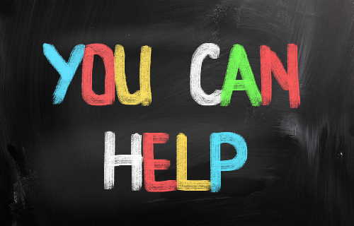 'YOU CAN HELP' written on a black board