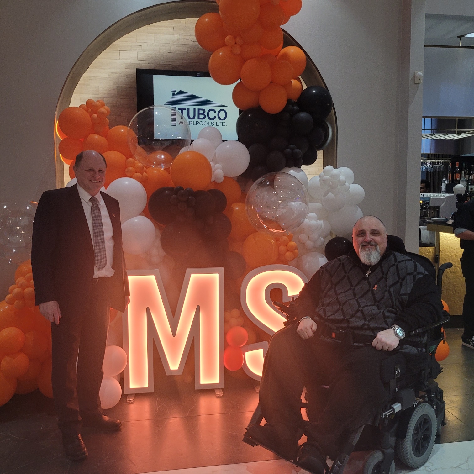 Francesco  Cuda sitting on a wheel chair and Peter standing far beside him